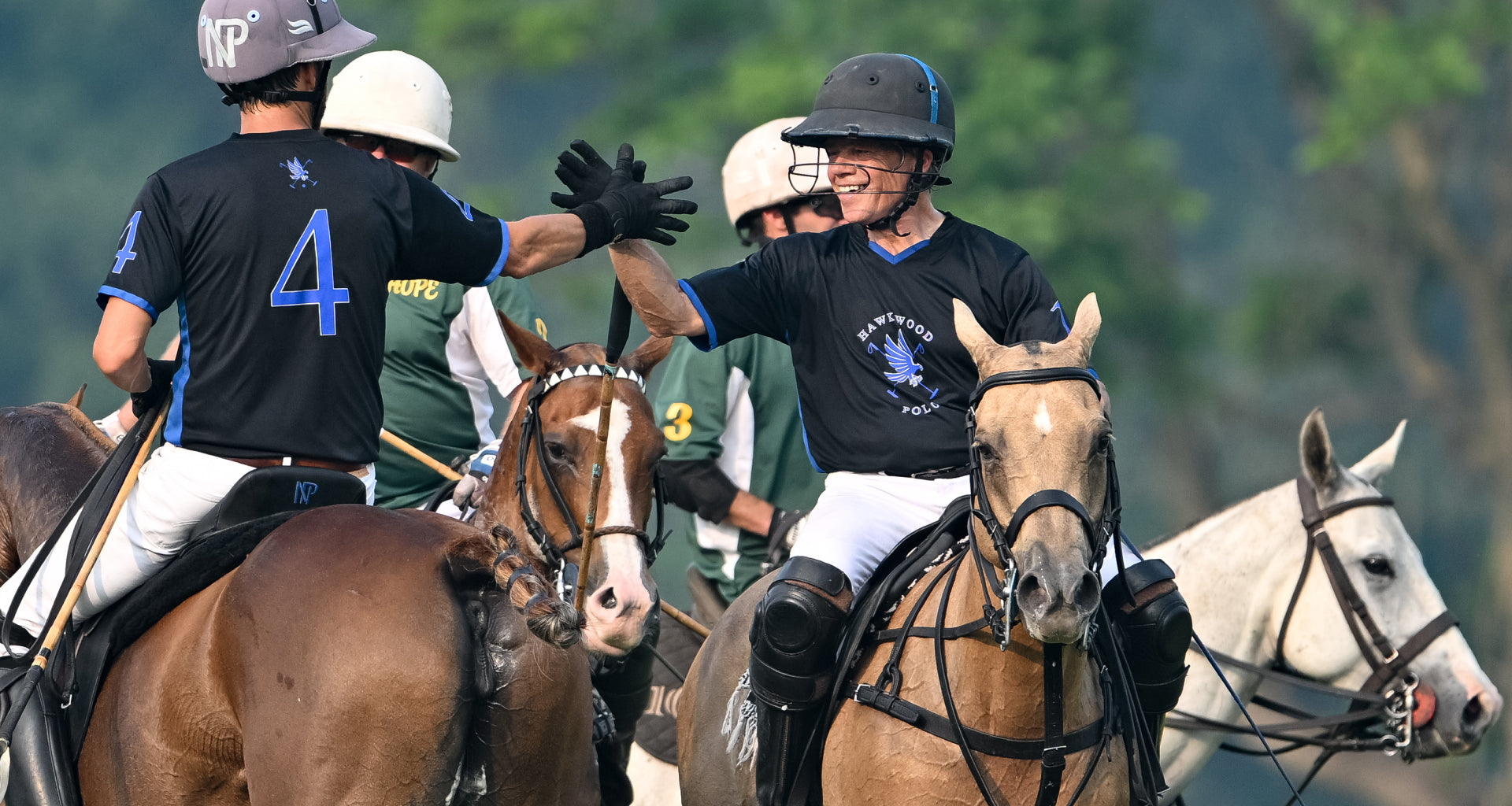 Players high fiving at a polo match